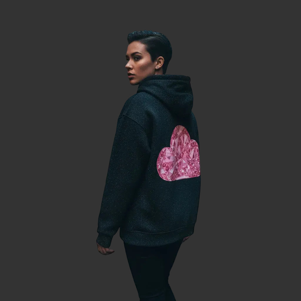 4iir black hoodie with a pink diamond cloud graphic on the back worn by a person in a city alleyway at dusk.