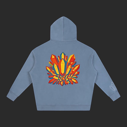 4iir Crystal Lava hoodie in dusty blue with a vibrant red and yellow crystal graphic on the back and sleeve detail.