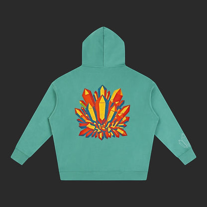 4iir Crystal Lava hoodie in teal with a vibrant red and yellow crystal graphic on the back and sleeve detail.