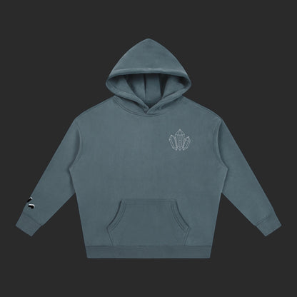 4iir Revenge hoodie in slate blue with a small white crystal chest graphic and sleeve detail on a dark background.